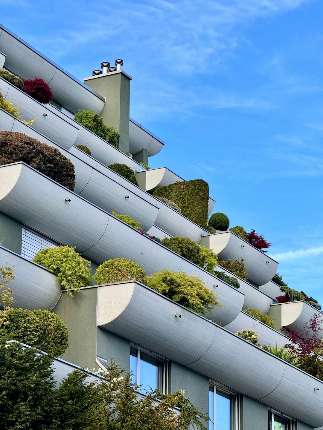 Moderne Balkone mit üppig grünen und violetten Pflanzen.